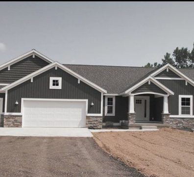 Dark gray house with white trim, stone accents, and a two-car garage.