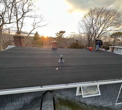 Flat roof with workers; sunset in background.