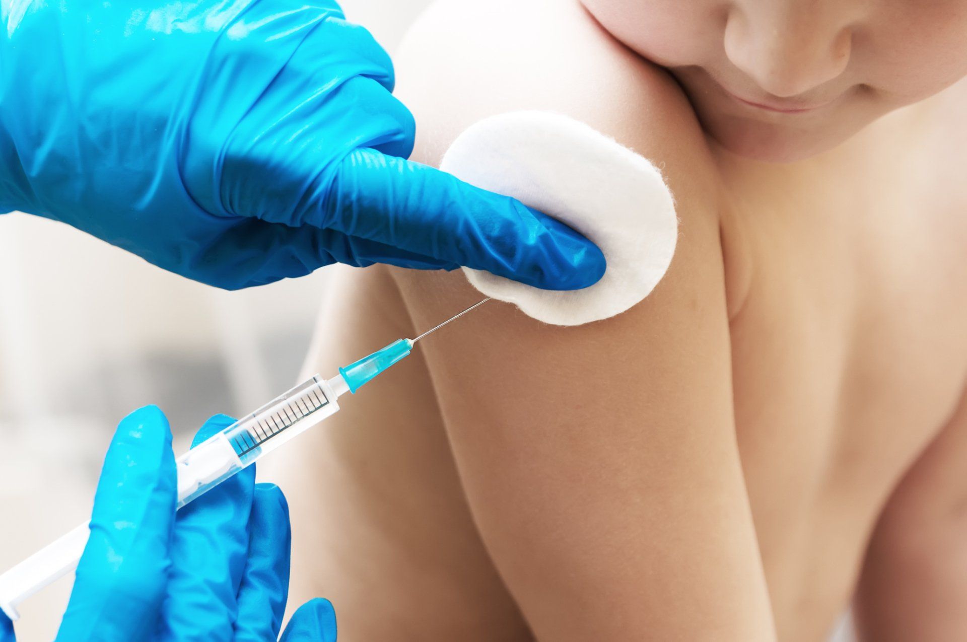 doctor injecting medicine into child's shoulder