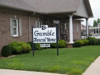 Gamble Funeral Home sign in front of a brick building and green lawn