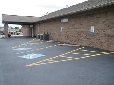 Accessible parking spaces beside a brick building under a covered walkway