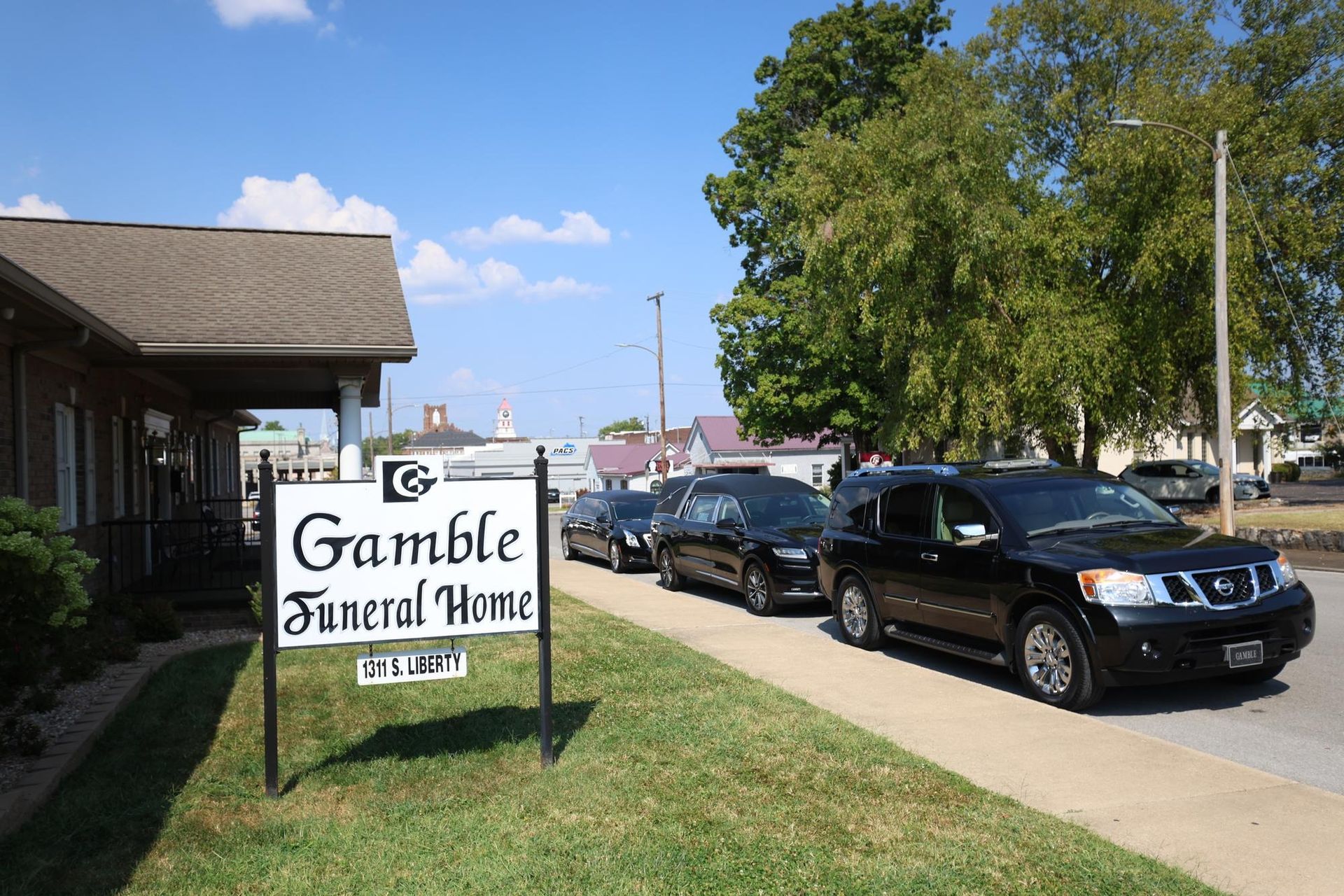 Gramble Funeral Home sign beside parked cars on a sunny street
