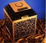 a black and gold urn vault is sitting on top of a piece of cloth .