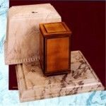 a wooden urn vault is sitting on top of a marble block .