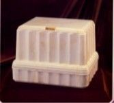 a white urn vault is sitting on top of a red cloth on a table .