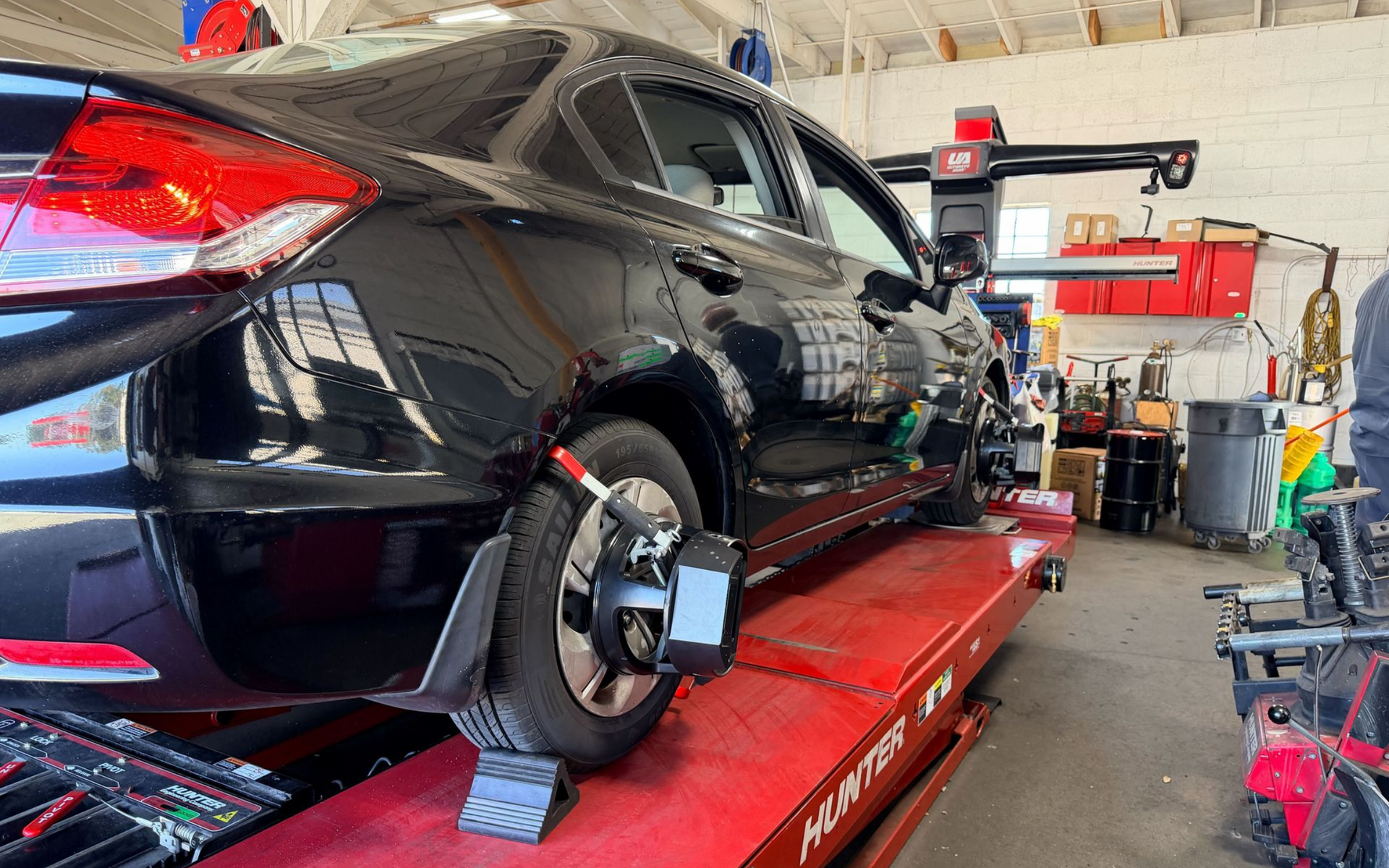 Technician performing wheel alignment service at Wayside Garage in Seaside CA