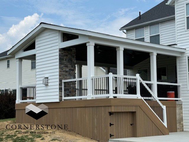 A white house with a porch and a cornerstone logo