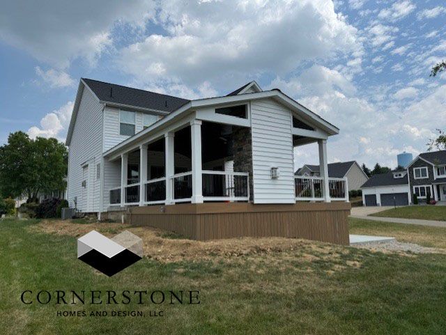 A white house with a screened in porch and a logo for cornerstone