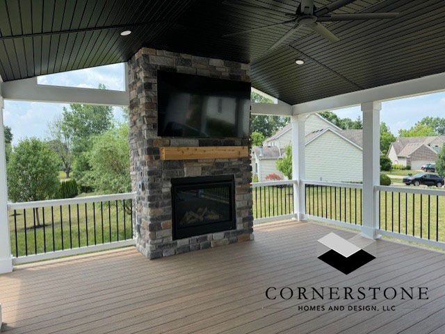 A porch with a fireplace and a flat screen tv.