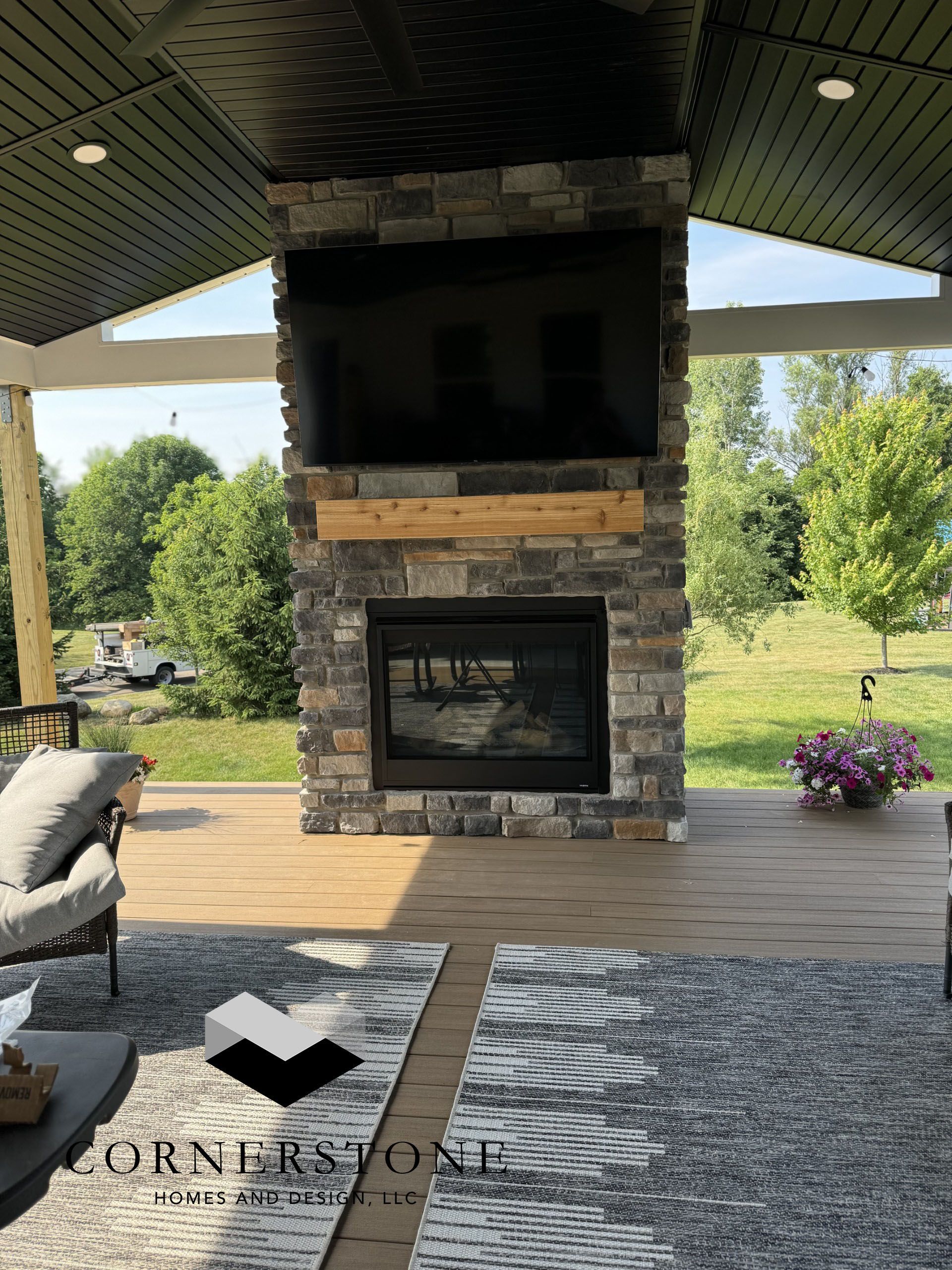 A stone fireplace with a flat screen tv mounted above it.