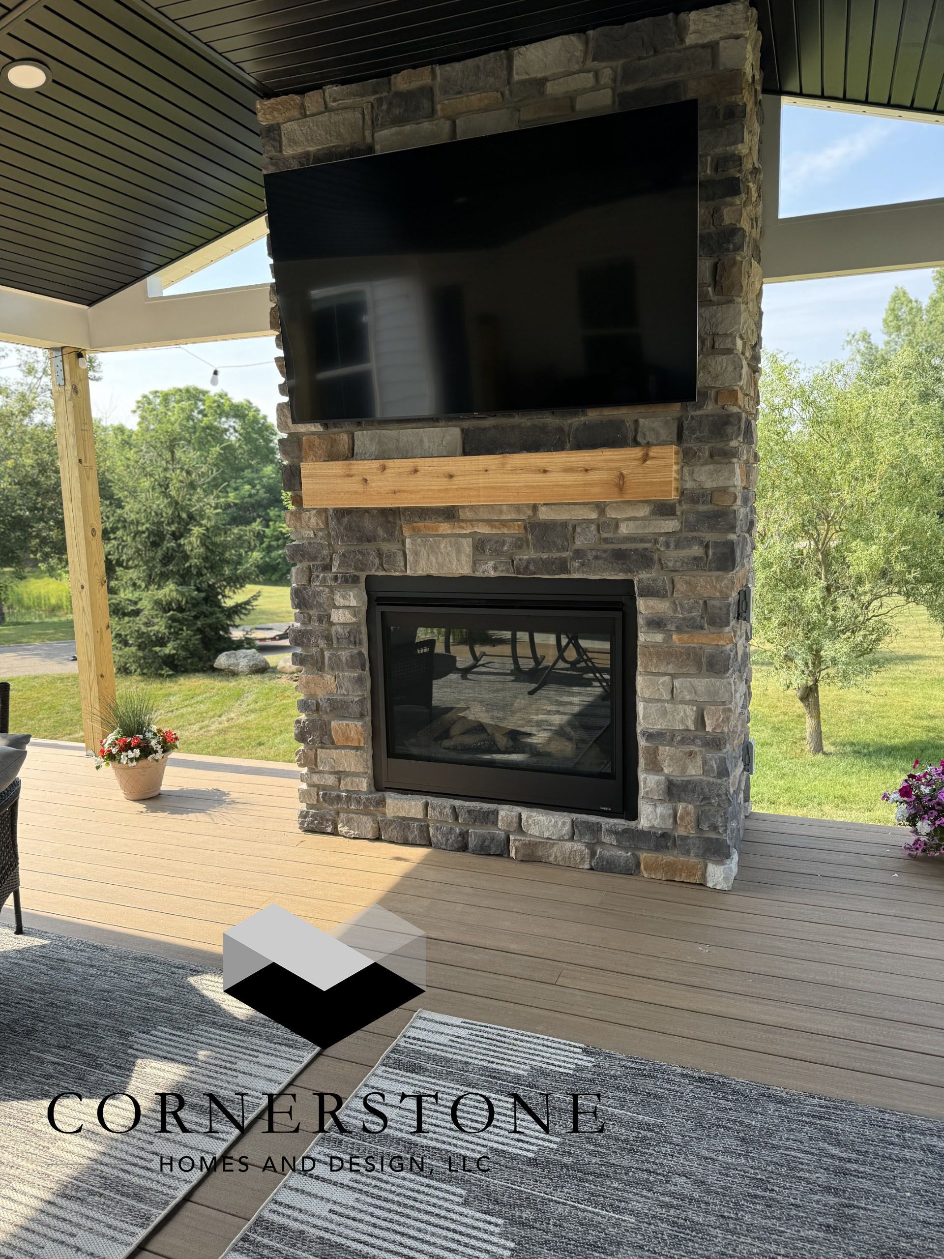 A stone fireplace with a flat screen tv mounted on the wall.