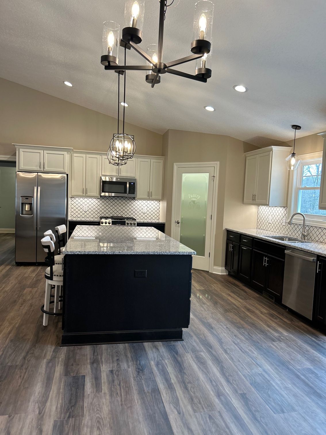 A kitchen with a large island and a chandelier hanging from the ceiling.