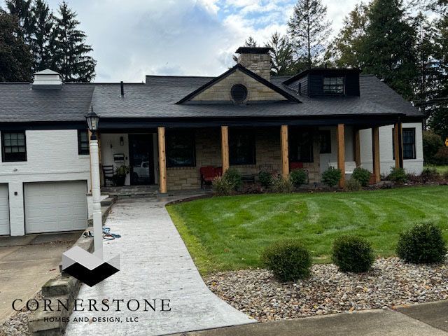 Suburban house with stone porch, attached garage, and landscaped front lawn