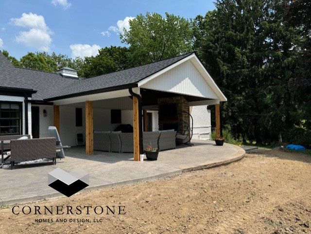 A house with a covered patio and a cornerstone logo
