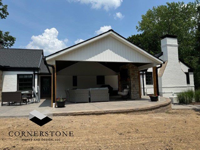 A white house with a patio and a logo for cornerstone