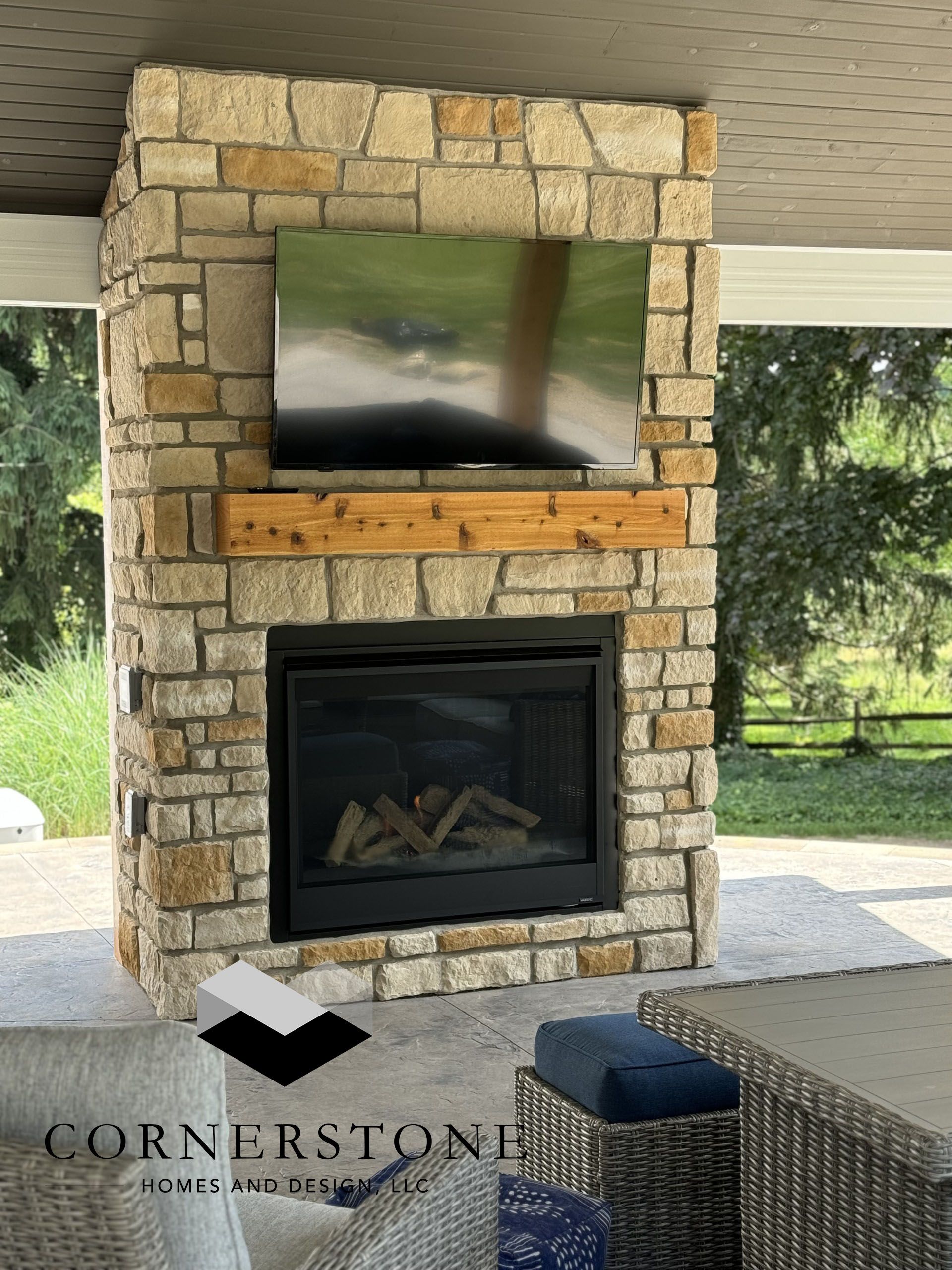 A stone fireplace with a flat screen tv mounted above it.