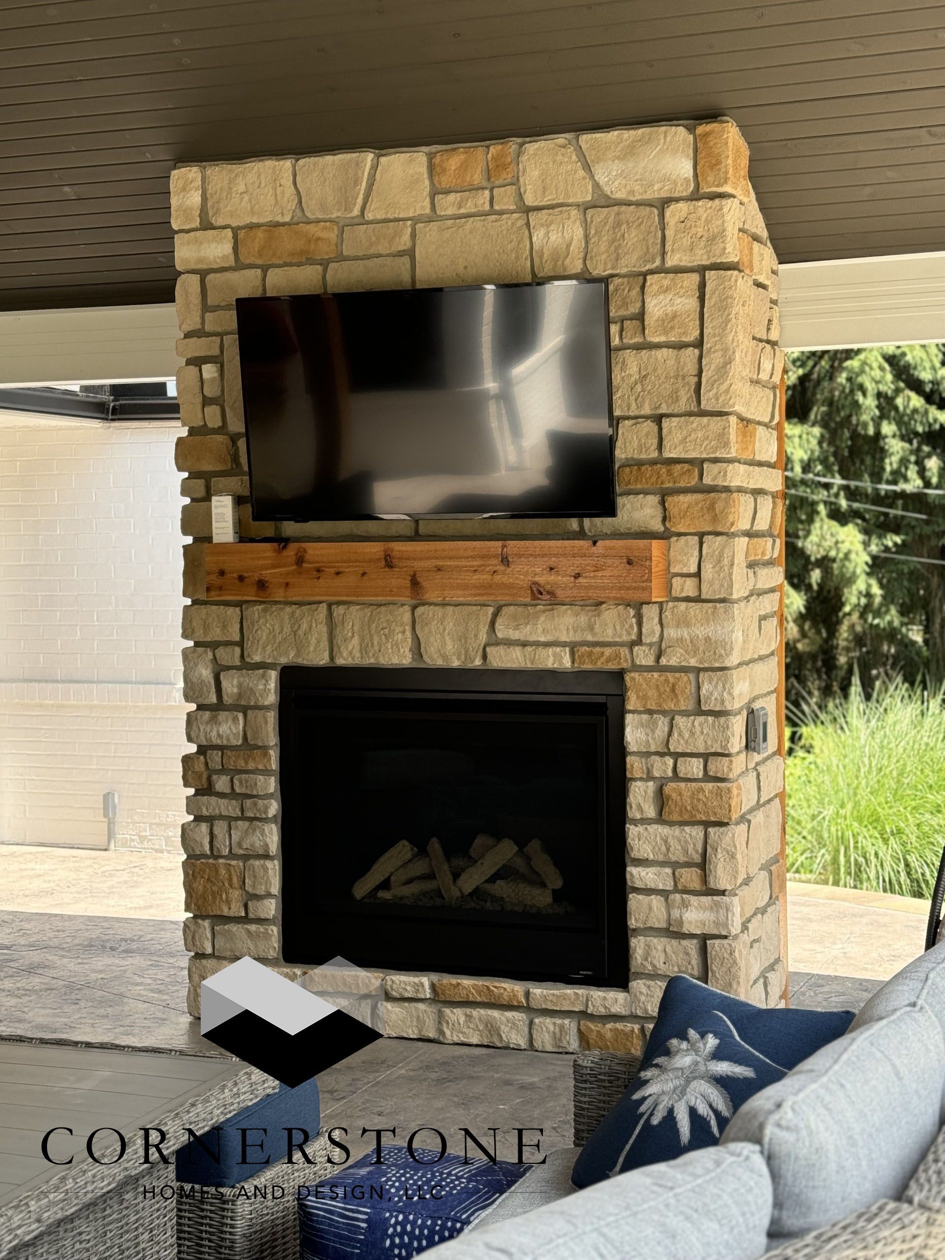 A stone fireplace with a flat screen tv above it
