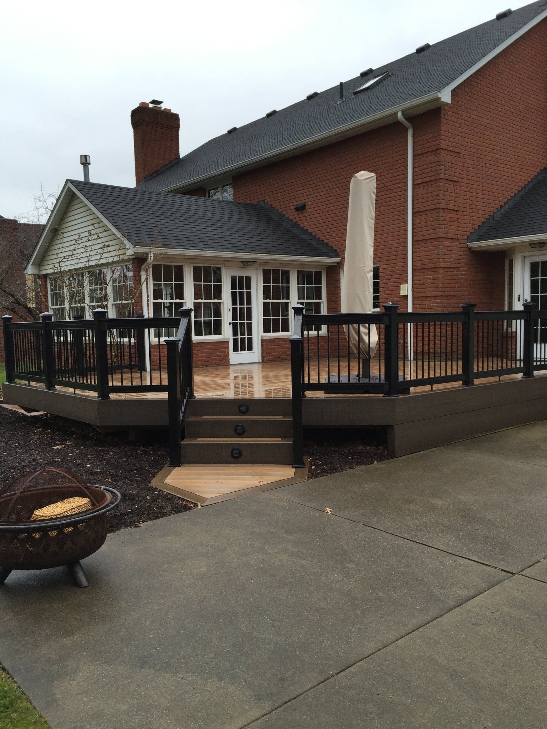 A large brick house with a large deck in front of it