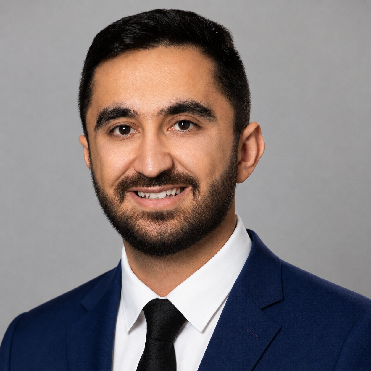 Jacob H. Zadeh in a suit and tie, smiling