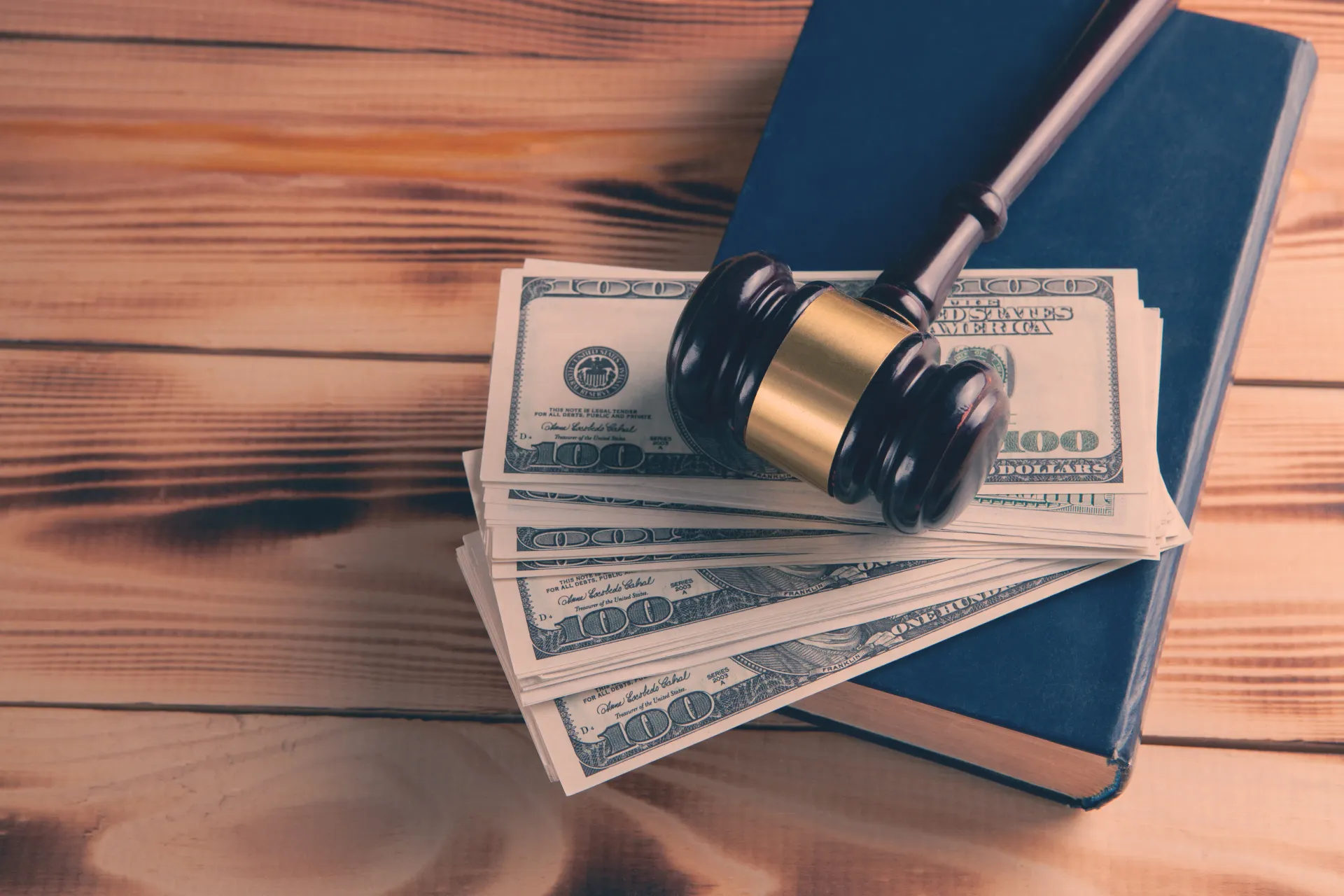Judge’s gavel resting on cash and a law book to represent bail payment plans in Van Nuys, CA