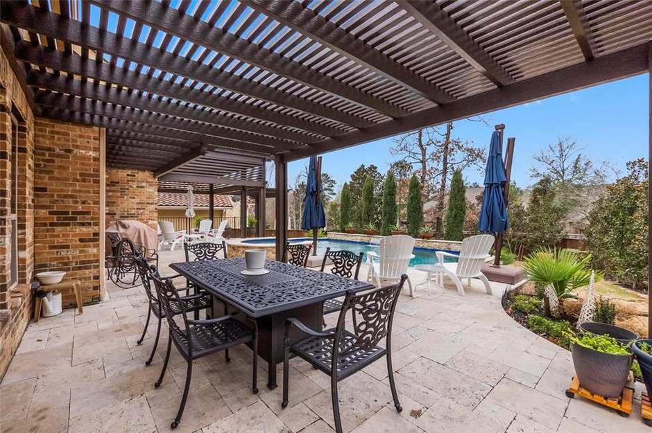Aluminum pergola providing shade for a seating area on a home in Houston, TX.