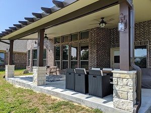 Covered patio build in Houston, TX with stone columns fans and lights