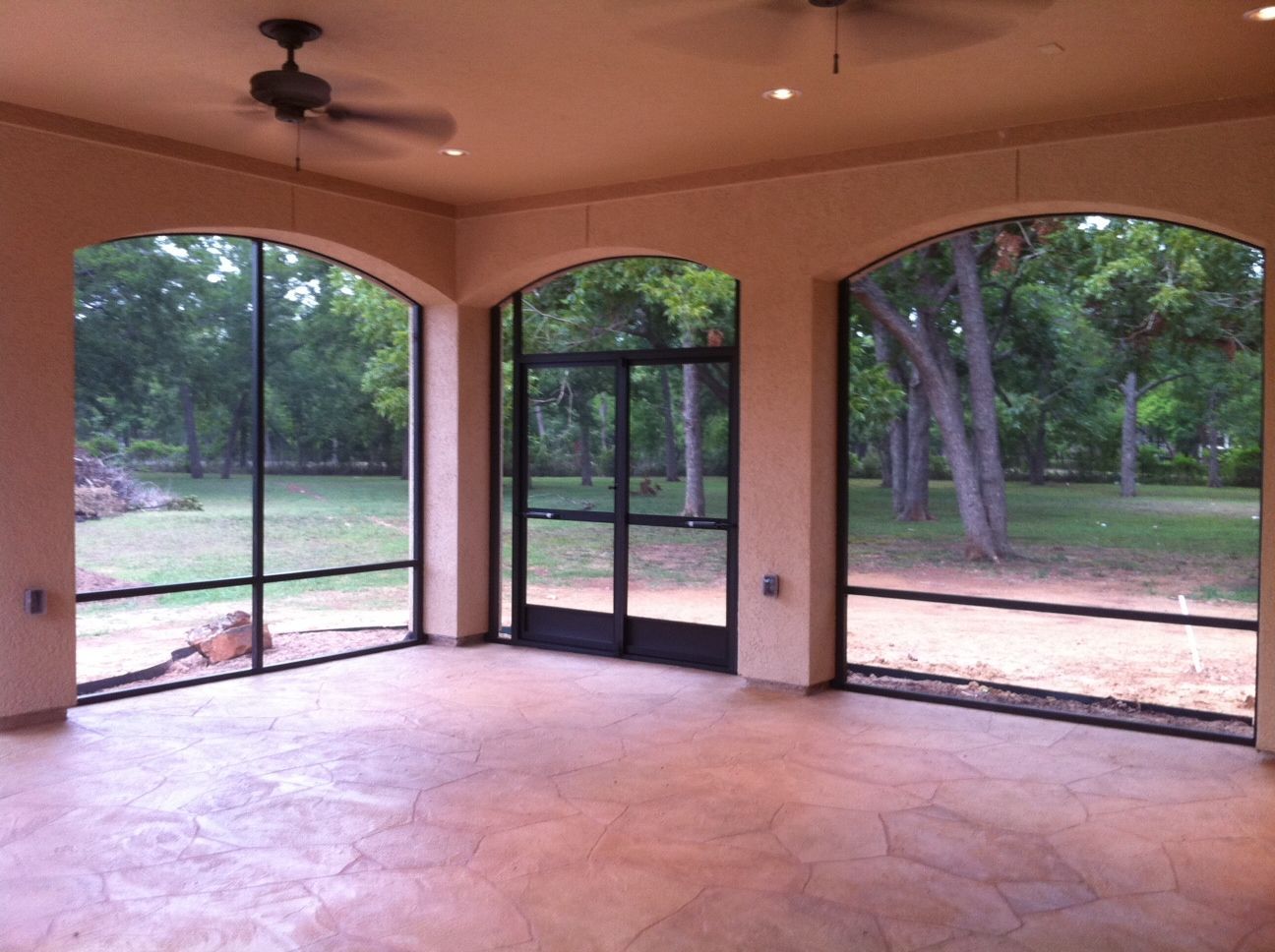 Screened Houston patio enclosure with ceiling fan and stamped concrete floor