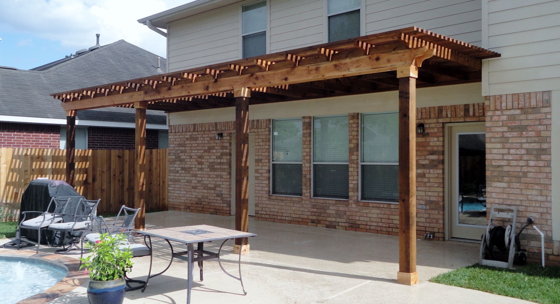 Custom cedar wood pergola installation with hurricane-rated engineering in Sugar Land, TX.