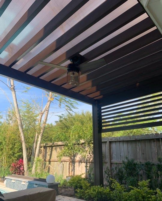 A modern pergola with a ceiling fan by a pool in the background built in Houston, TX.