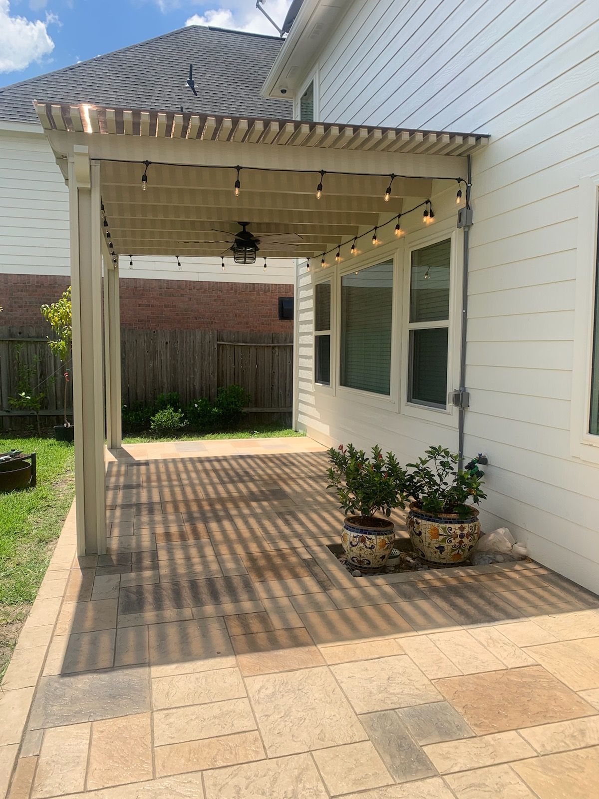 A brick house with an Alumawood pergola in Richmond, TX.
