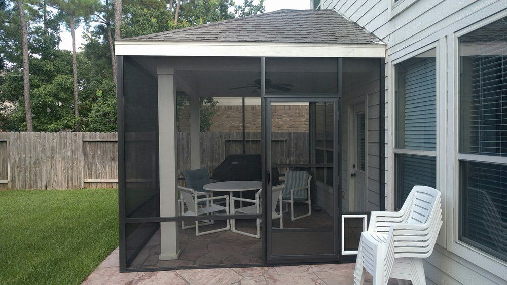 Pearland TX screen room with stone wall, attached to home for shaded outdoor relaxation.