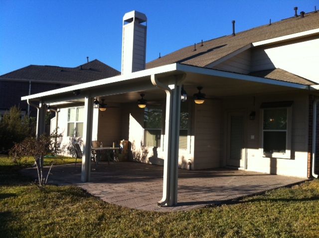 A covered patio near Houston with a stone floor and four support columns.