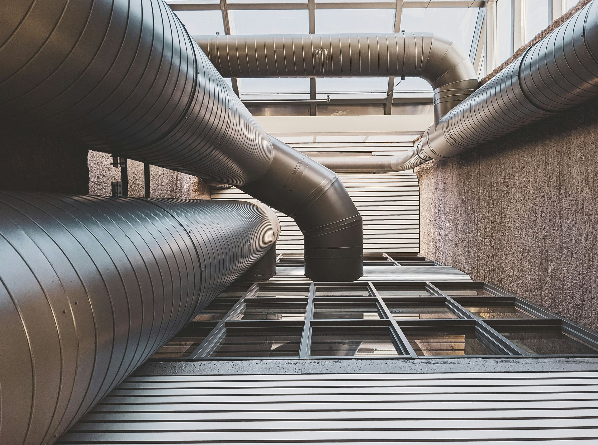 Industrial metal ventilation pipes viewed from below in a modern building shaft
