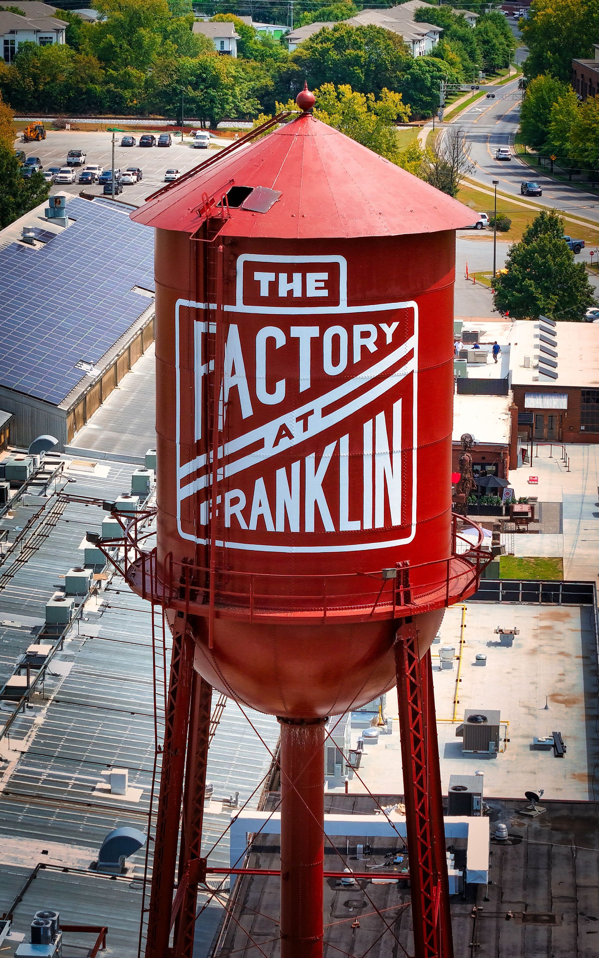 Red water tower labeled “The Factory at Franklin” old water tower