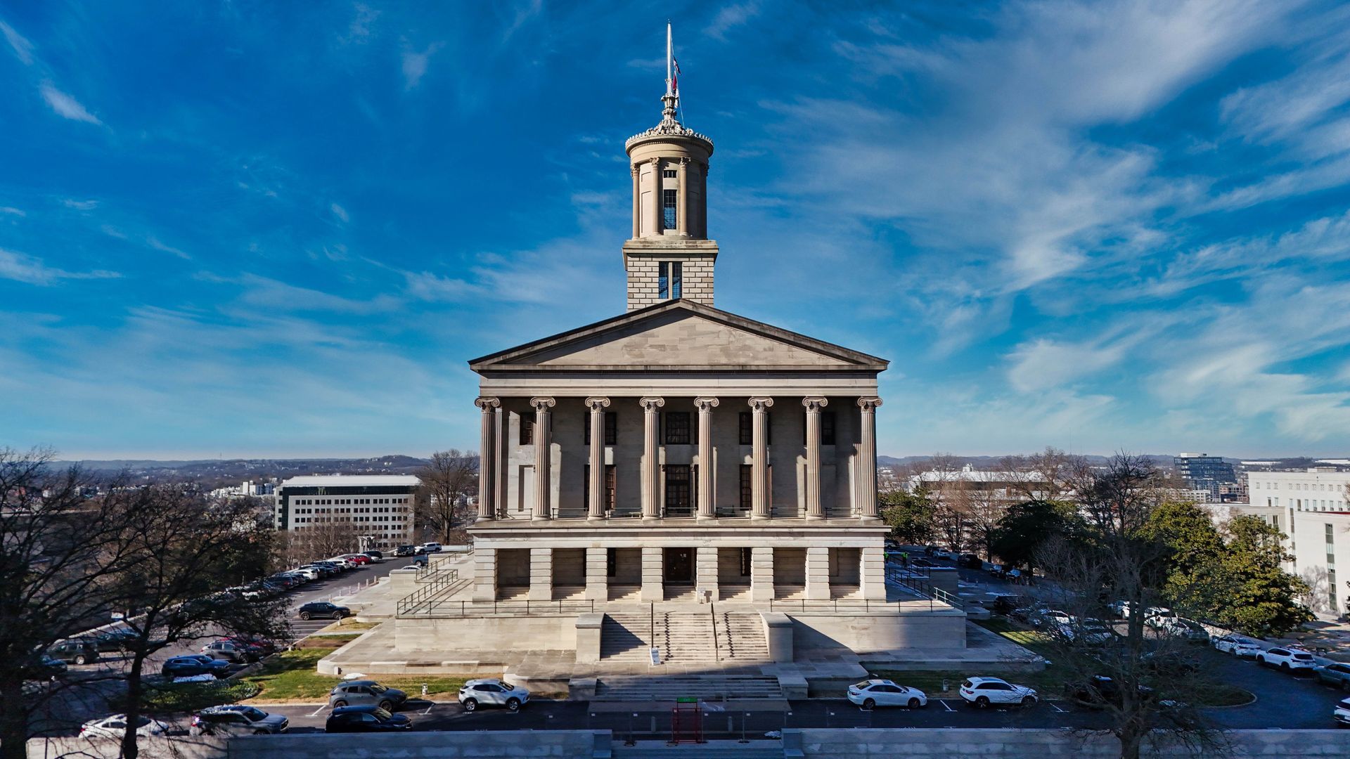 Historic neoclassical Nashville capitol building with tall columns and a central tower under a blue sky