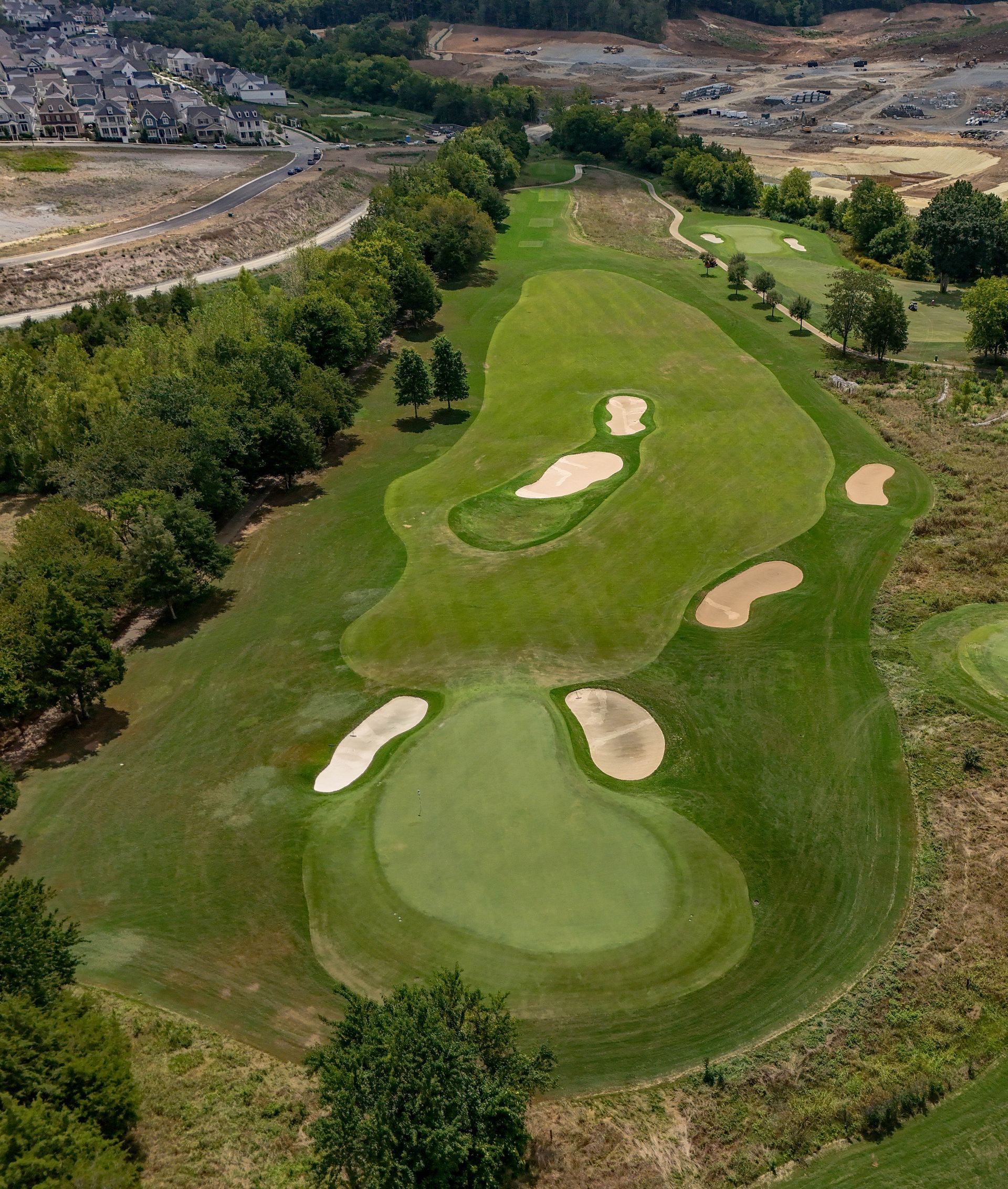 Aerial view of a golf course fairway with several sand bunkers and trees.