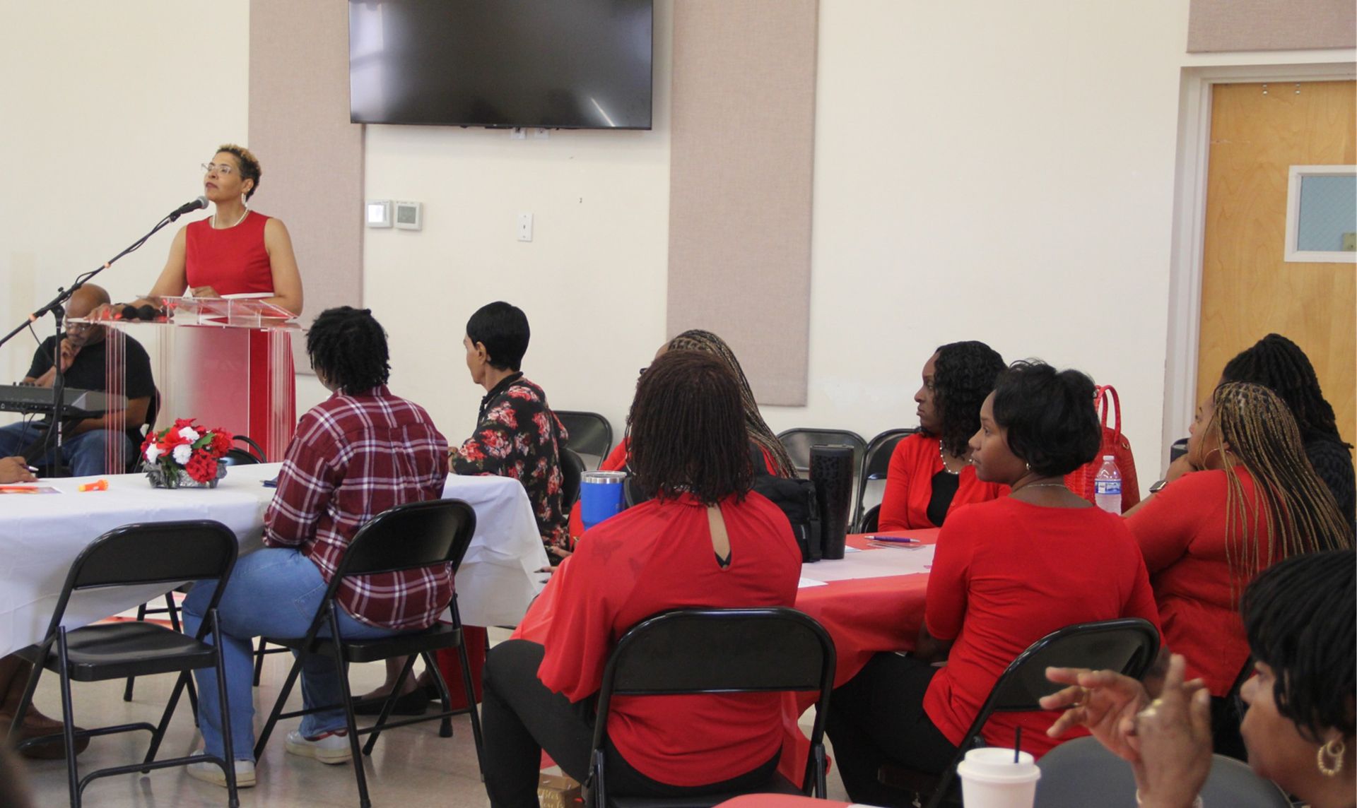 A group of women are sitting at tables in a room.