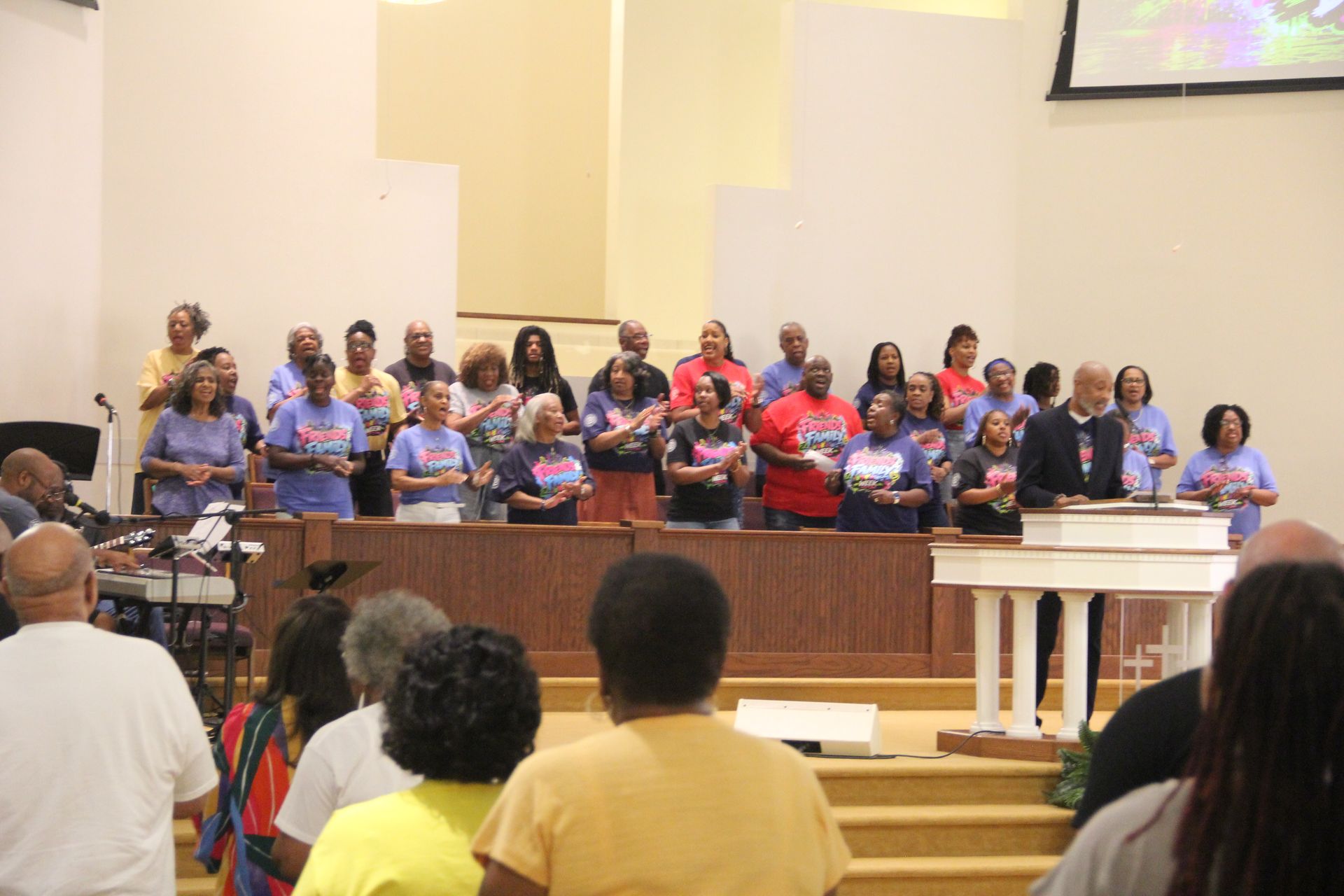 A group of people are sitting in chairs doing chair exercises.