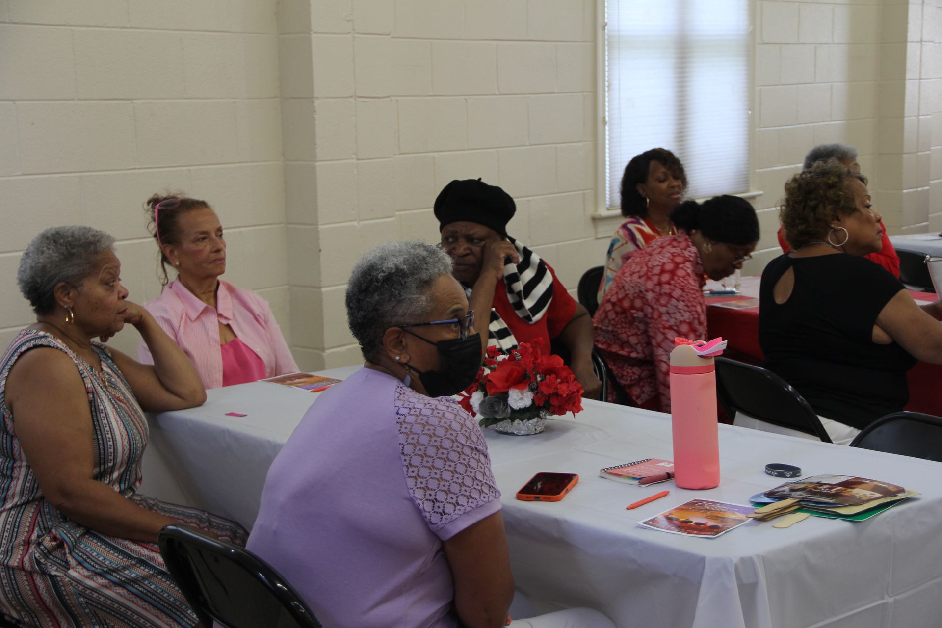 A group of women are sitting around a table in a room.