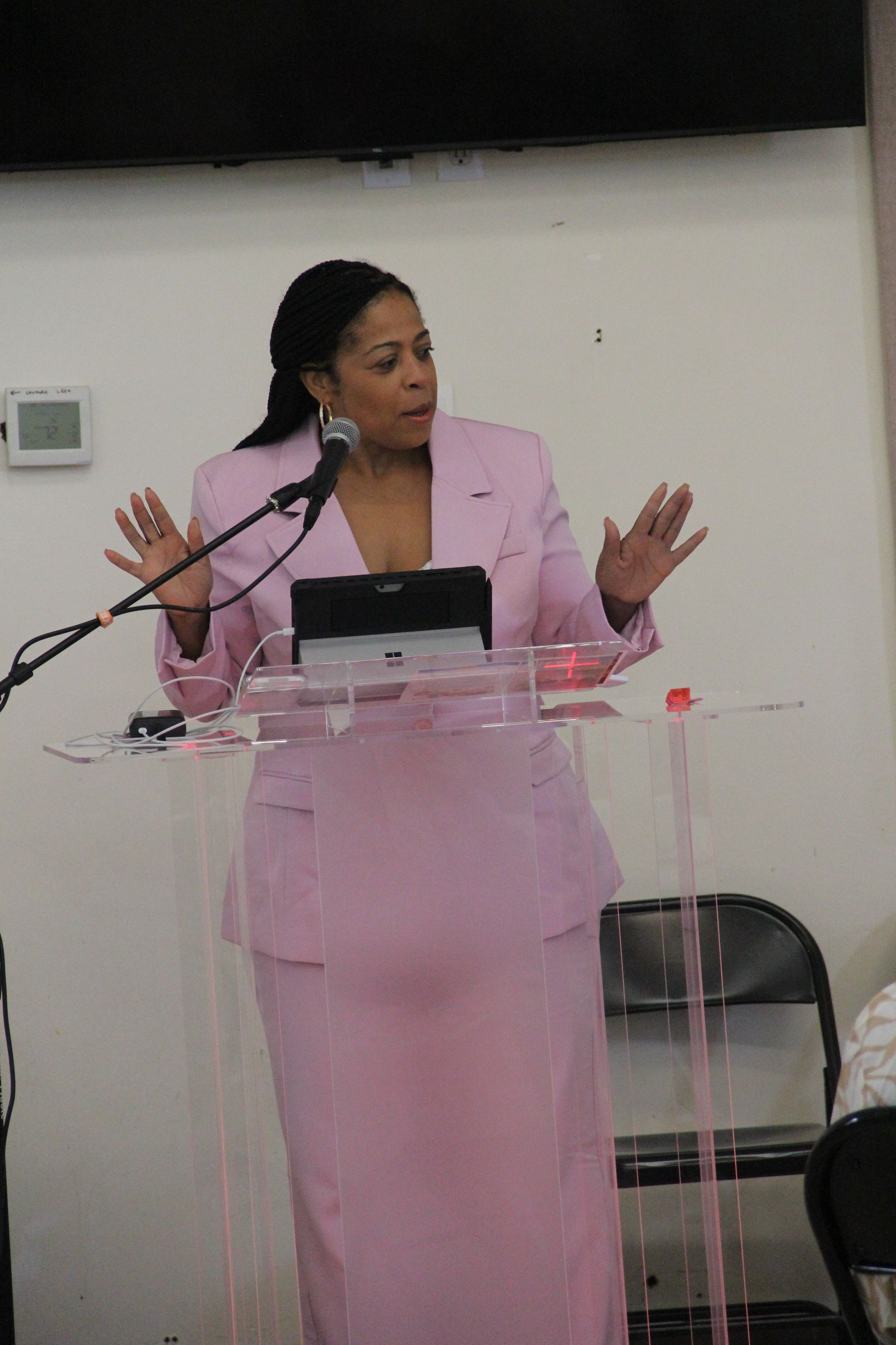 A woman is standing at a podium speaking into a microphone.