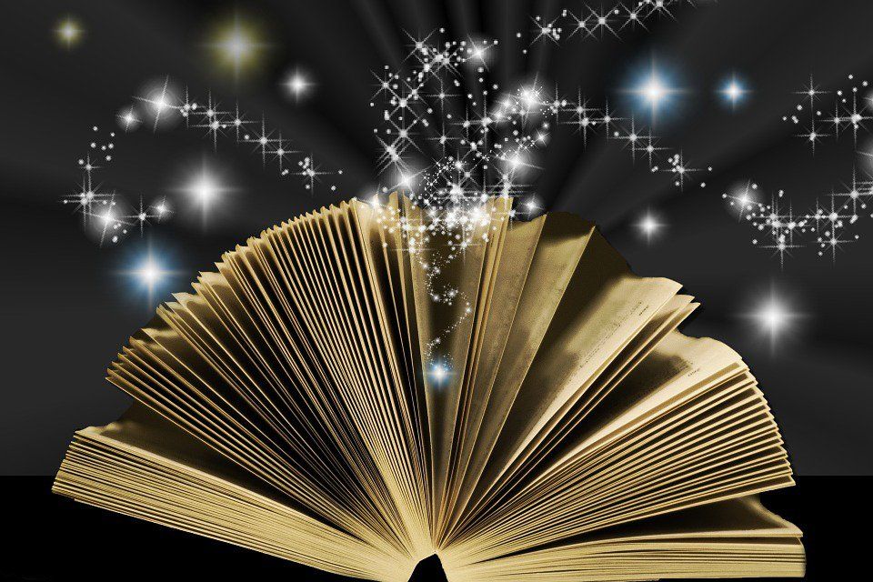 Open gold book with sparkling white stars on a black background