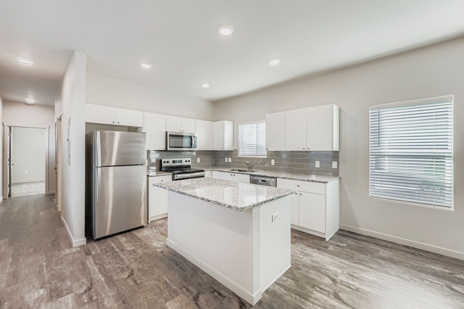 Bright modern kitchen with white cabinets, stainless steel appliances, and a central island