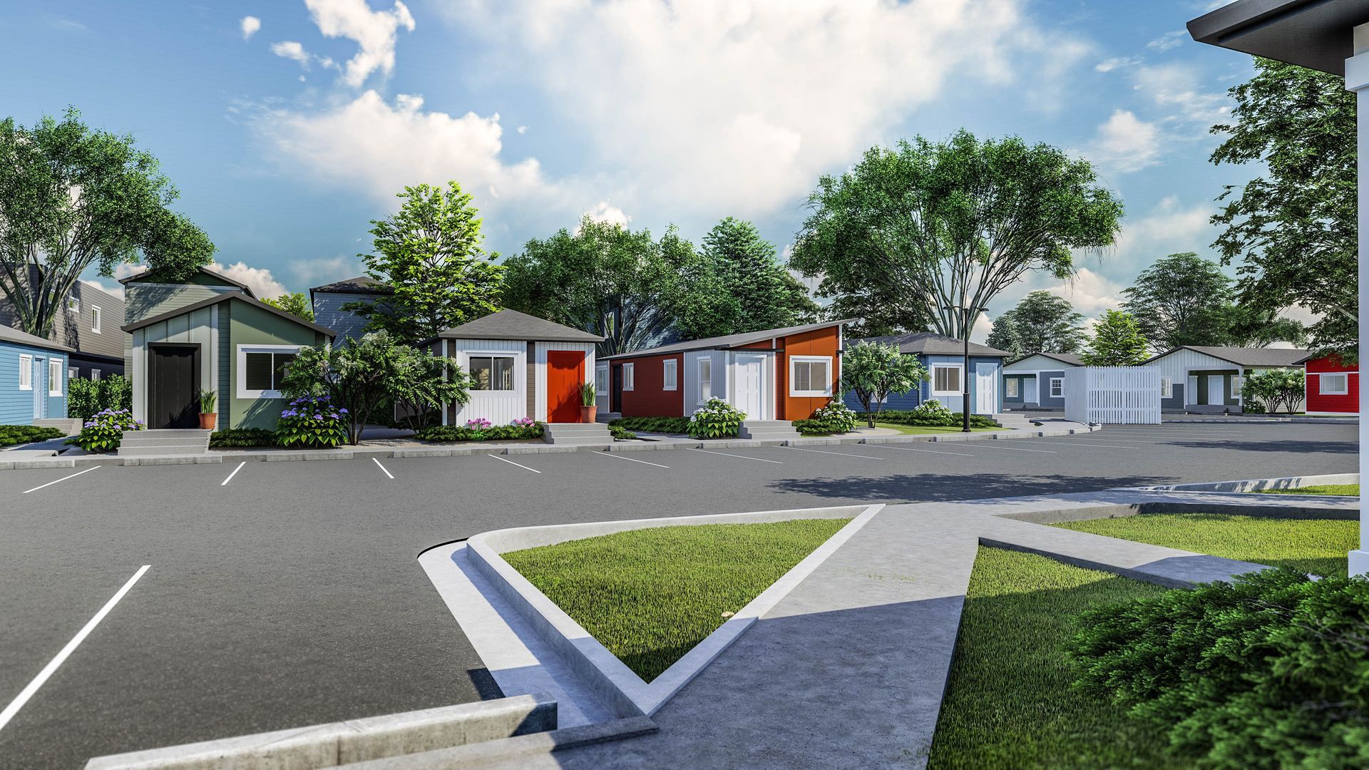 Modern suburban townhomes with paved parking, green lawns, and a clear blue sky