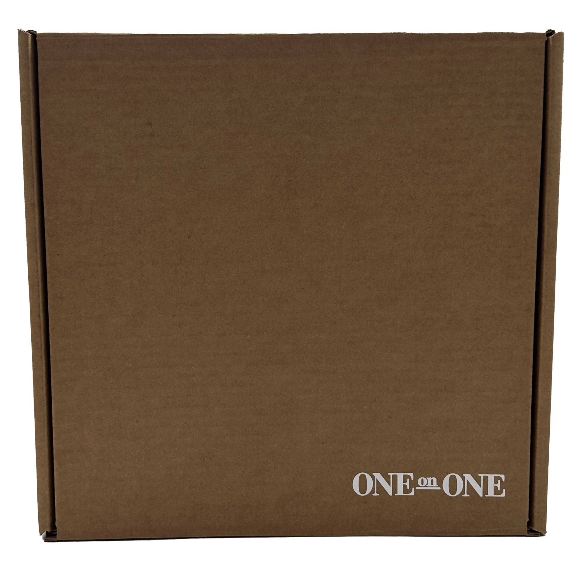 Caja de cartón marrón con la inscripción “ONE on ONE” impresa en blanco en la parte inferior derecha.