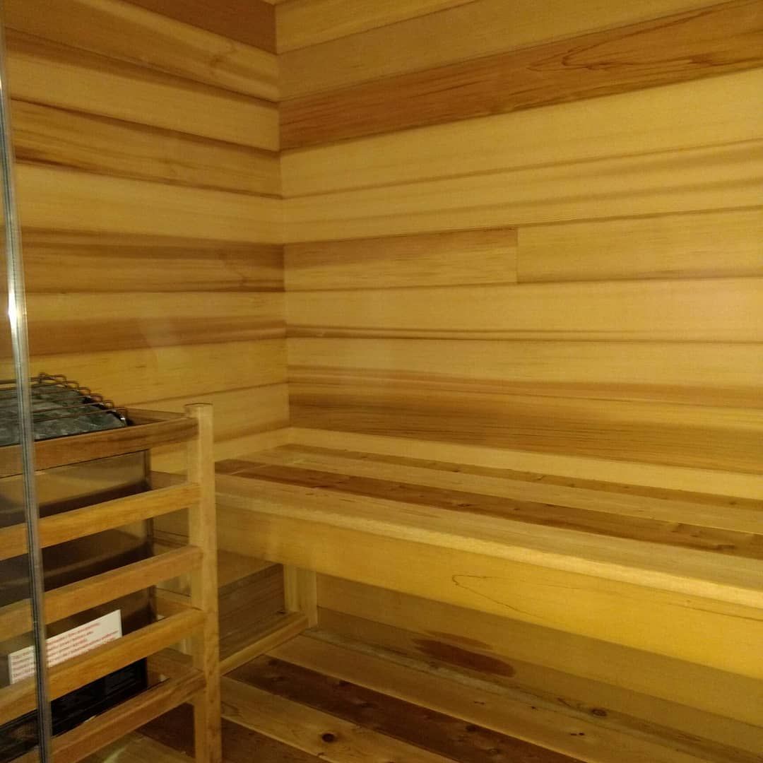 Wooden sauna interior with benches and heating element.