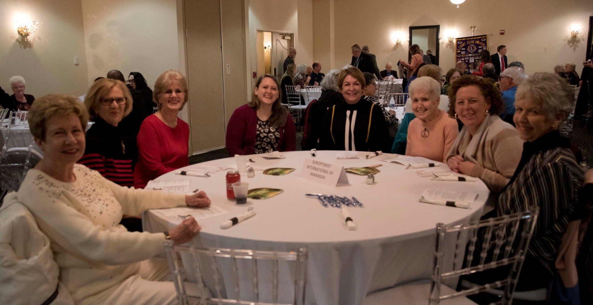 A group of women are sitting around a round table.