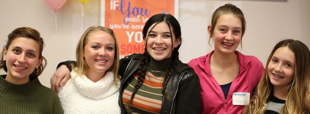 A group of young women are posing for a picture together.