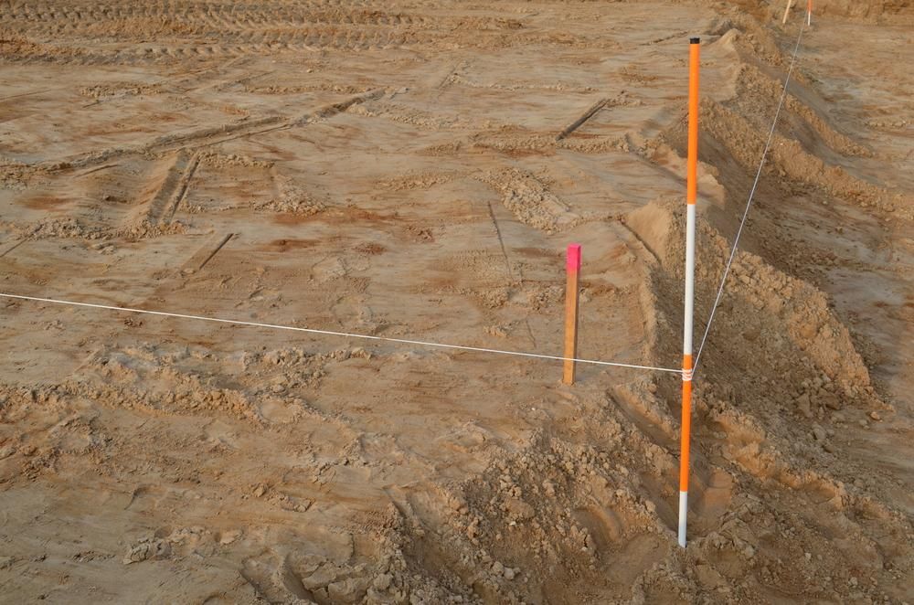 A Construction Site with A Few Markers in The Sand — Duggan Mather Surveyors in Taylors Beach, NSW
