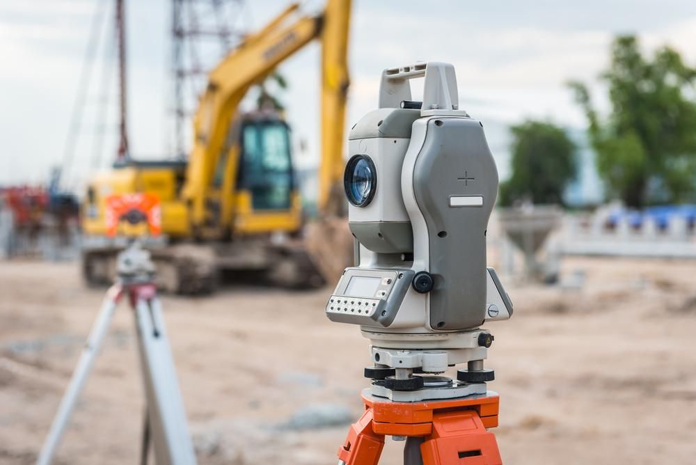 A Theodolite Is Sitting on A Tripod on A Construction Site — Duggan Mather Surveyors in Forster, NSW