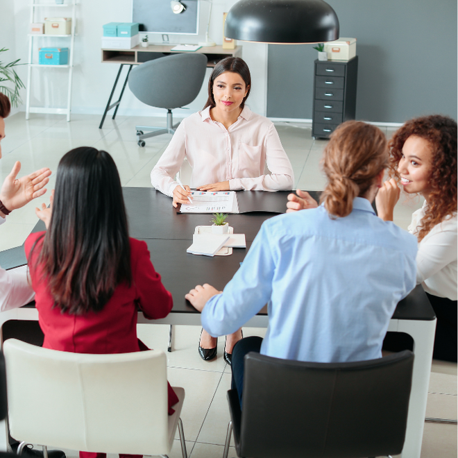 A group of people are sitting around a table having a meeting
